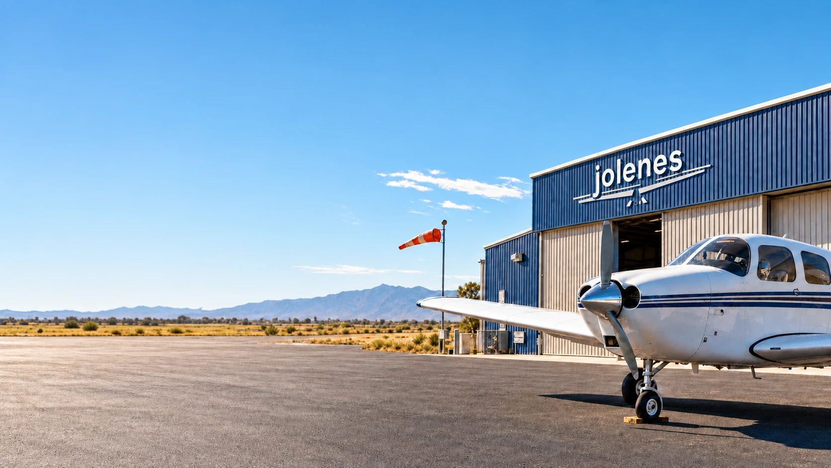 Illustrative aviation scene with a small aircraft beside a hangar under a clear blue sky.
